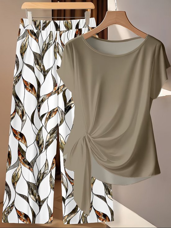 Khaki kledingset met wijde broek met bladprint en strikblouse.