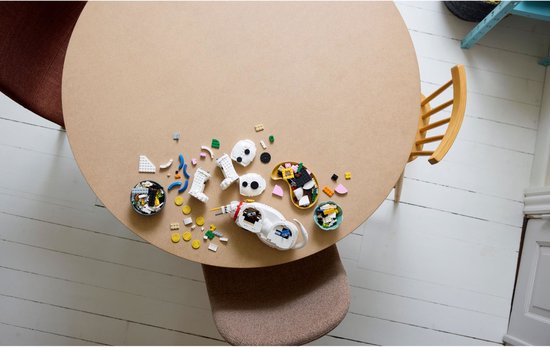 Une table avec des pièces LEGO, dont deux ensembles de construction de Dalmatiens, une perceuse et divers blocs.