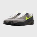 Grijze Nike Air Max 90 sneakers met witte veters, neon groene accenten en zwarte zool.