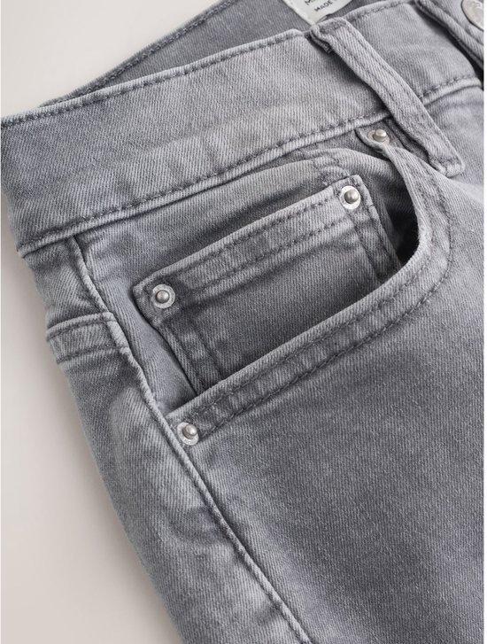 Close-up van de zakken en tailleband van een grijze jeans.