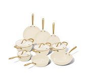 Set van negen beige pannen met gouden handvatten, waaronder koekenpannen, kookpannen, een steelpan, hapjespan en wokpan, op zwarte achtergrond.