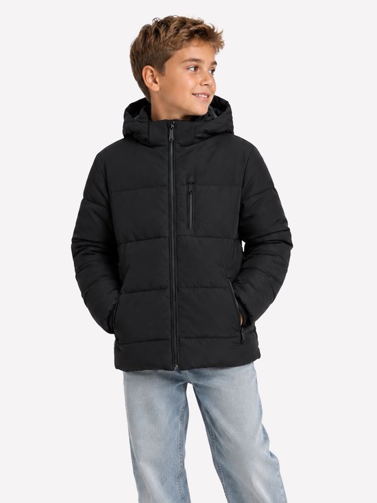 Jongen met een zwarte pufferjas met capuchon en blauwe jeans.