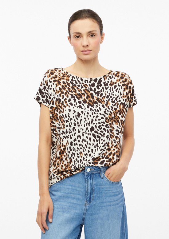 Model met luipaardprint T-shirt in beige en bruin, met spijkerbroek.