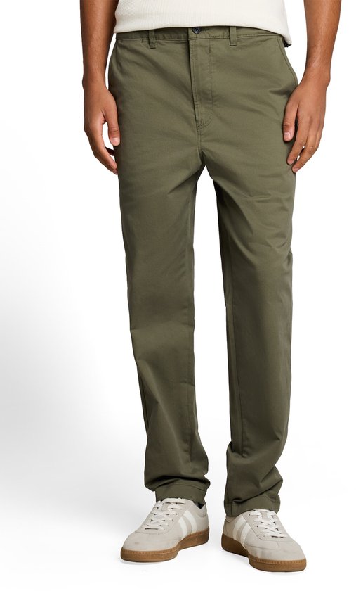 Rechte, olijfgroene chino broek met relaxte pasvorm, gedragen door een model met witte sneakers.