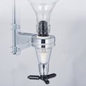 Een close-up van een chromen drankdispenser met glazen reservoir en zwarte hendel.