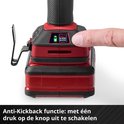 Vinger drukt op de rode knop van de boormachine, met een groen "ANTI KICK BACK" indicatorlicht.