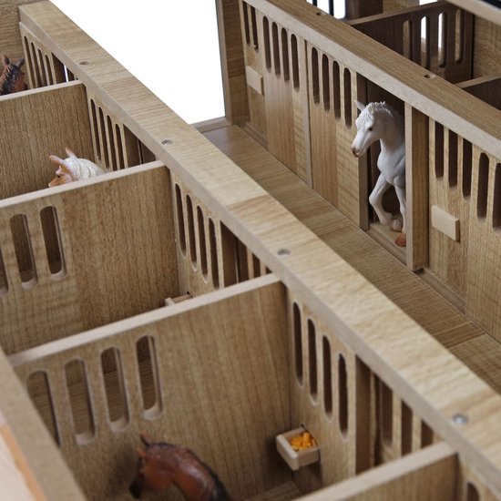 Houten paardenstal interieur met paarden in de boxen, houten schuttingen en voerbakjes.