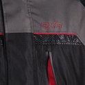 Close-up van een zwarte en grijze motorjas met rode DXR-logo en mesh detail.