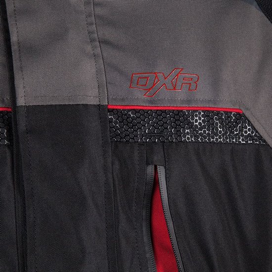 Close-up van een zwarte en grijze motorjas met rode DXR-logo en mesh detail.