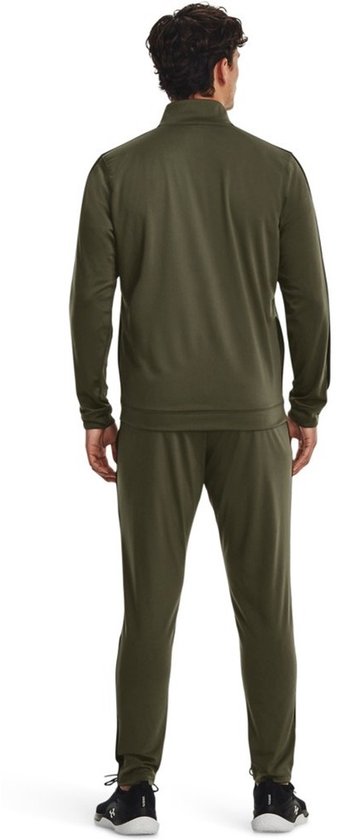 Achterkant van een man met groen Under Armour trainingspak. Zwarte strepen op de mouwen en zijkanten van de broek.