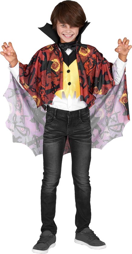 Garçon en costume de vampire avec cape à motif toile d'araignée et petits yeux, gilet jaune et jean noir.