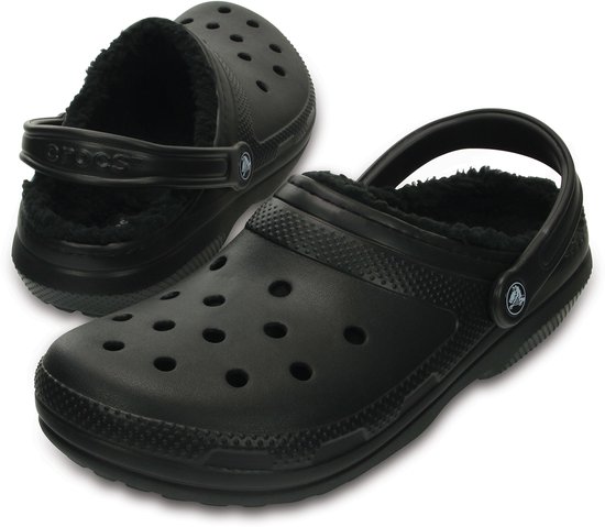 Een paar zwarte Crocs met imitatiebont voering, de ene voor en de andere schuin van voren gezien.