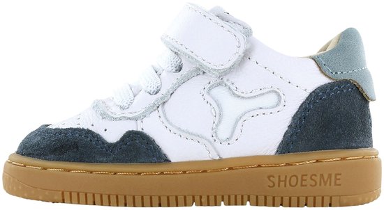 Wit leren sneaker met donkerblauwe suède details en bruine zool. Klittenbandsluiting en veters.