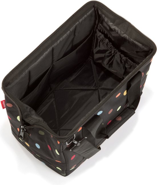 Zwarte reistas met veelkleurige stippen, open met vakken en een trekkoordvak.