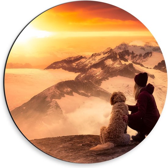 Dibond Wandcirkel - Vrouw met Hond op Bergtoppen Kijkend naar Zonsondergang - 30x30cm Foto op Aluminium Wandcirkel (met ophangsysteem)