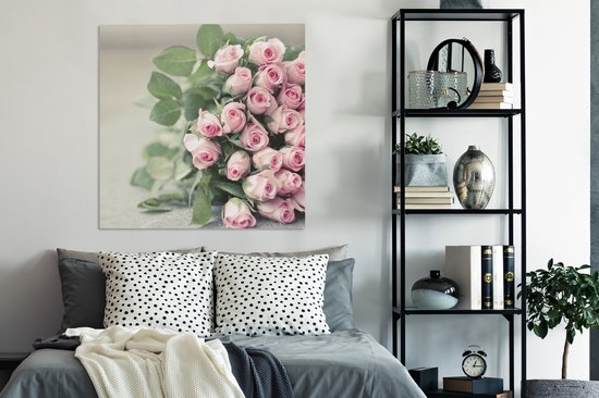 Un grand livre de roses roses repose sur une table Toile 90x90 cm - Tirage photo sur toile (Décoration murale salon / chambre) / Peintures Fleurs sur toile
