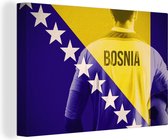 Canvas Schilderij Voetballer achter de vlag van Bosnië en Herzegovina - 60x40 cm - Wanddecoratie