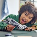Een jongen speelt met de LEGO Star Wars Pirate Snub Fighter en een minifiguur.