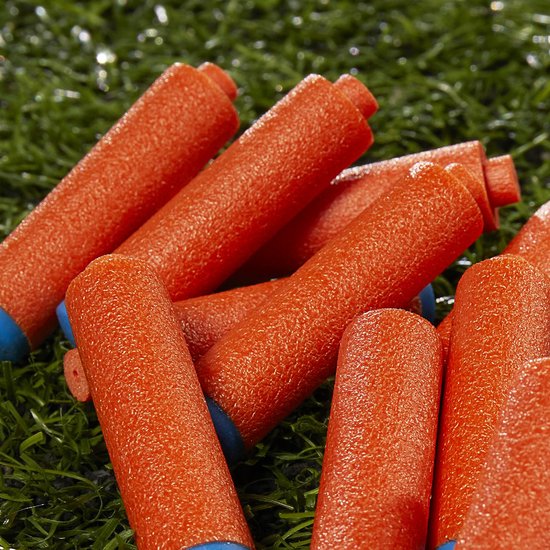 Een stapel oranje Nerf pijltjes met blauwe doppen, liggend op groen gras.