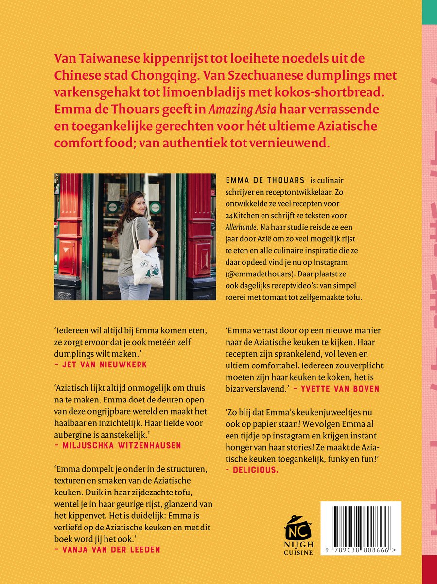 Een jonge vrouw met bruin haar, gekleed in een grijs T-shirt, staat voor een rode kast vol receptenboeken en Chinese snuisterijen. Ze draagt een tas met het logo 'Emma de Thouars'.