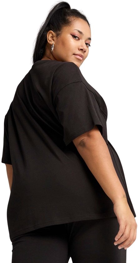 Model in zwart PUMA oversized T-shirt met korte mouwen en een hoge halslijn. Het shirt is van katoen en heeft een losse pasvorm.