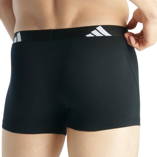 Achterkant van een zwarte Adidas boxer, gedragen door een man. Witte tailleband met logo.