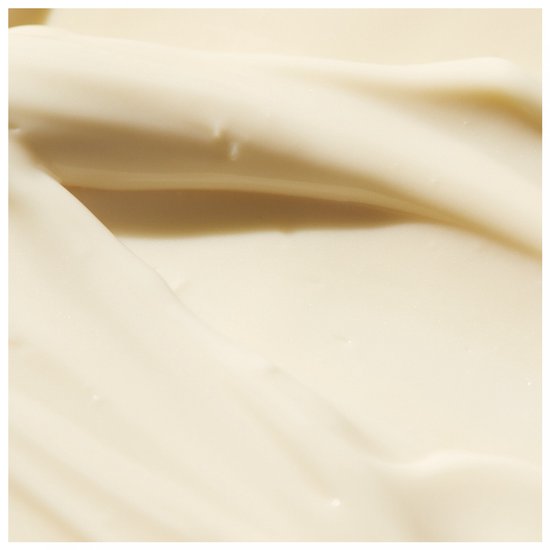 Close-up van een romige witte lotion, golvende textuur.