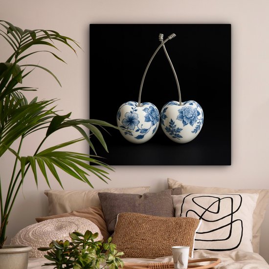 Delfts blauwe kersendecoratie aan de muur boven een bed in een slaapkamer.