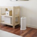 Witte Ubbi luieremmer naast een houten commode in een babykamer met een houten vloer.