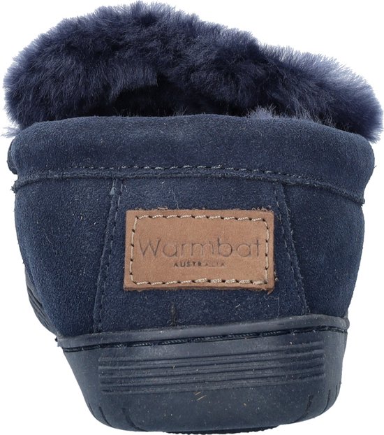 Achterkant van donkerblauwe suède slof met bont voering en bruin 'Warmbat Australia' label.