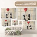 Peinture de street art avec deux enfants et un ballon rouge, présentée en différentes tailles au-dessus d'un canapé.
