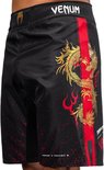 Zijaanzicht van zwarte fightshorts met gouden draak, rode streep en rode spetters.