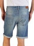 Achterkant, man draagt blauwe denim short met omgeslagen broekspijpen en Riverso-label.