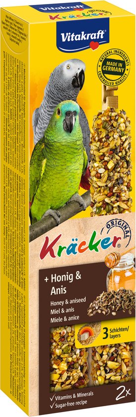 Gele verpakking van Vitakraft Kräcker met twee papegaaien, honing & anijs smaak, natuurlijke ingrediënten, made in Germany.