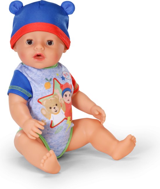 Jongen met blauwe muts en romper met beerprint. Zittend op witte achtergrond.