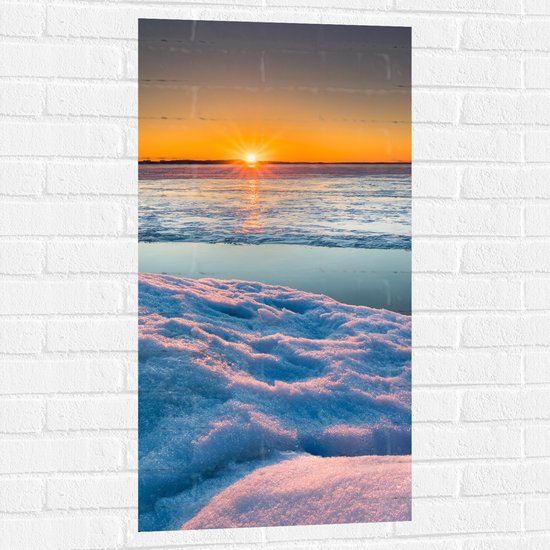 WallClassics - Muursticker - Ondergaande Zon bij Meer in de Sneeuw - 50x100 cm Foto op Muursticker
