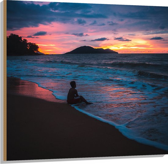 WallClassics - Hout - Persoon zittend op Strand met Zonsondergang - 100x100 cm - 12 mm dik - Foto op Hout (Met Ophangsysteem)