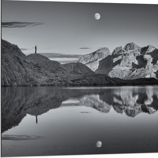WallClassics - Dibond - Persoon op Rotsen langs Water met Maan in zwart-wit - 80x80 cm Foto op Aluminium (Met Ophangsysteem)