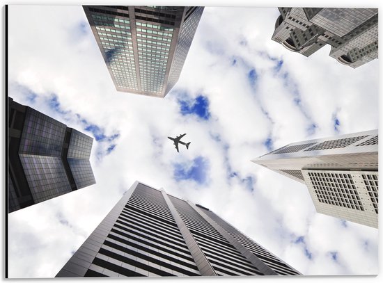 Dibond - Vliegtuig tussen Gebouwen in de Lucht - 40x30 cm Foto op Aluminium (Met Ophangsysteem)