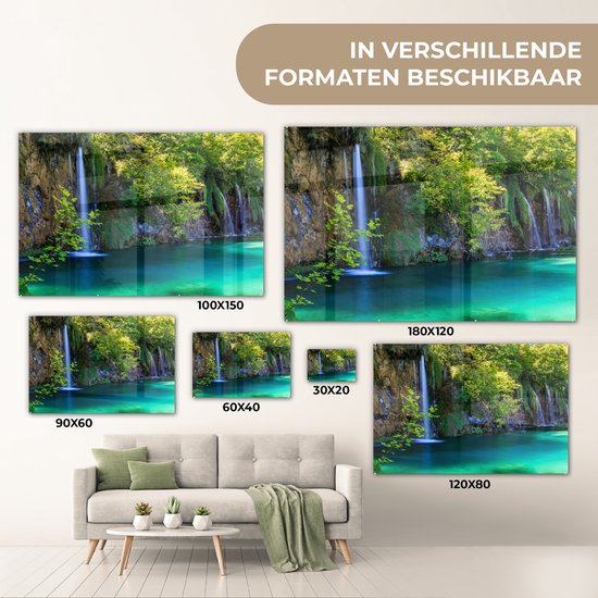 Acrylglas schilderij van de Plitvicemeren met waterval en turquoise water, getoond in diverse formaten boven een bank.