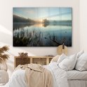 Une peinture sur verre d'un lever de soleil sur un lac brumeux, dans une chambre avec un lit.
