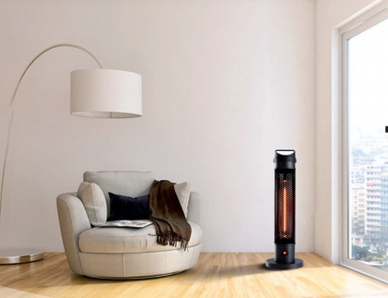 Zwarte staande infrarood heater in een woonkamer bij een fauteuil en een raam.