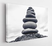 Canvas schilderij - Stones pyramid on pebble beach symbolizing stability, zen, harmony, balance. Shallow depth of field -     561959941 - 115*75 Horizontal