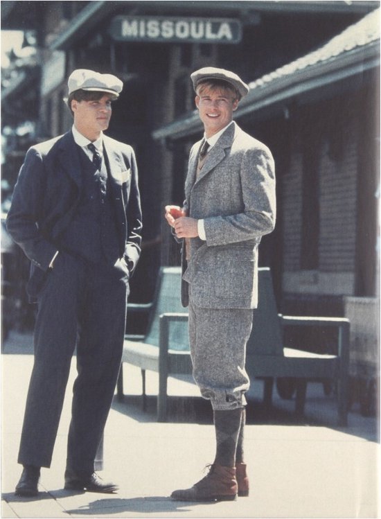 Twee mannen in vintage kleding staan bij een treinstation met "Missoula" boven hen.