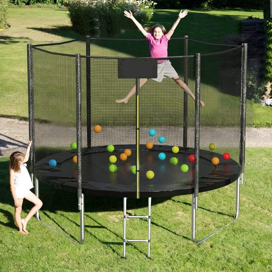 Twee kinderen spelen op een ronde trampoline in de tuin. Eén kind springt, het andere kijkt toe.