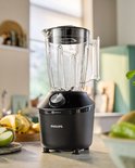 Zwarte Philips blender met een glazen kan, op een aanrecht met fruit.