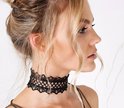 Zijaanzicht van een model met opgestoken haar, die een zwarte, kanten choker met opengewerkt patroon draagt.
