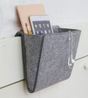 Grijze vilten nachtkastje opberger met tablet, boek, potlood en oortjes.