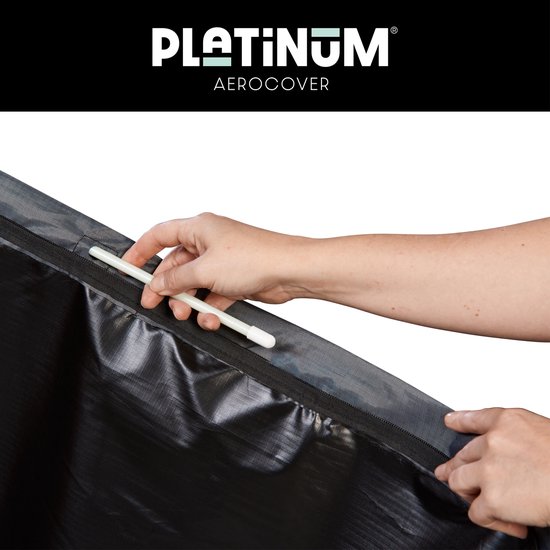 Hand sluit een grijze parasolhoes met een rits en witte stok.