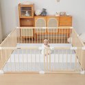 Baby in een ruime houten babybox met witte speelmat en een deur.
